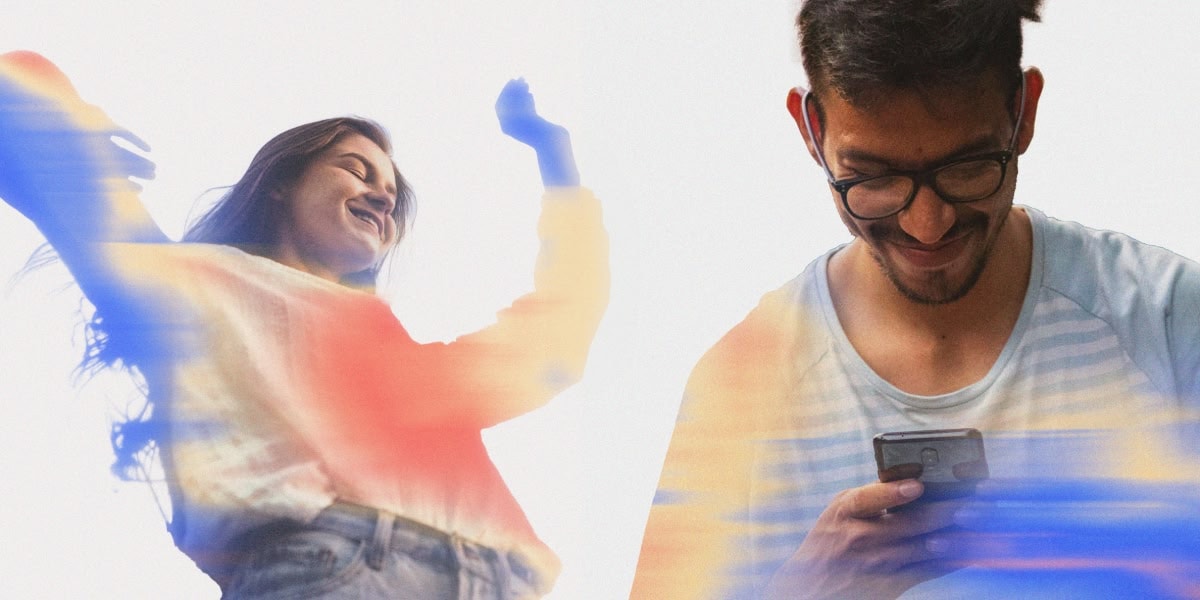Woman smiling. Man using phone.